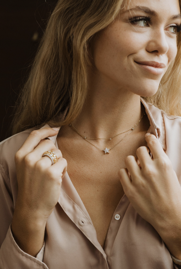 Close-up of model wearing dainty diamond necklace.