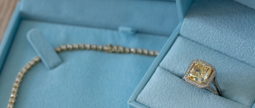 A diamond necklace and diamond ring on blue velvet
