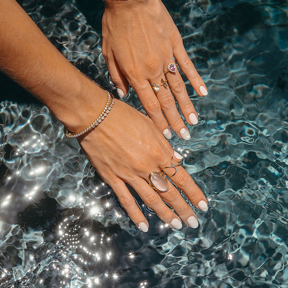 hands in water with antique rings and bracelet from Miriam's Jewelry